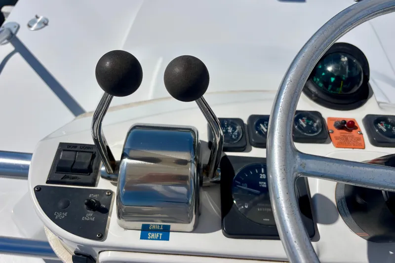 Slide: The Image of Control panel of a 2002 Luhrs 32 Open boat with steering wheel and throttle levers. - 31