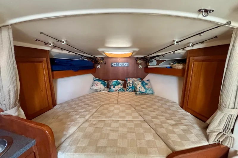 Slide: The Image of Cozy cabin interior of 2002 Luhrs 32 Open boat with decorative pillows and wooden storage. - 42
