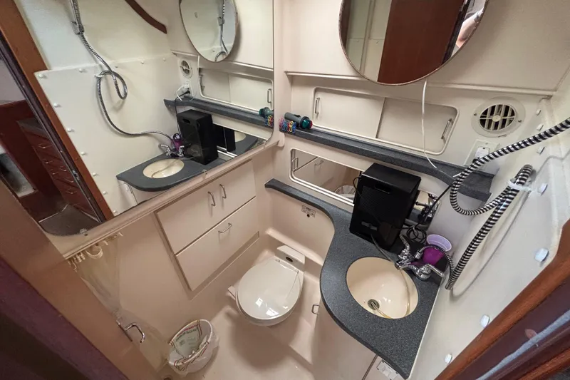 Slide: The Image of Bathroom interior of 2002 Luhrs 32 Open boat, featuring sink, toilet, and storage cabinets. - 47