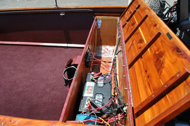 Slide: The Image of Open wooden compartment with batteries and wiring in a 2014 Custom Underwood boat. - 19