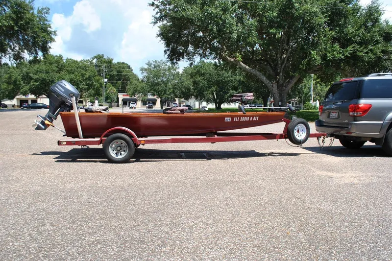 Slide: The Image of Custom Underwood boat on trailer hitched to SUV, parked outdoors, 2014 model. - 4
