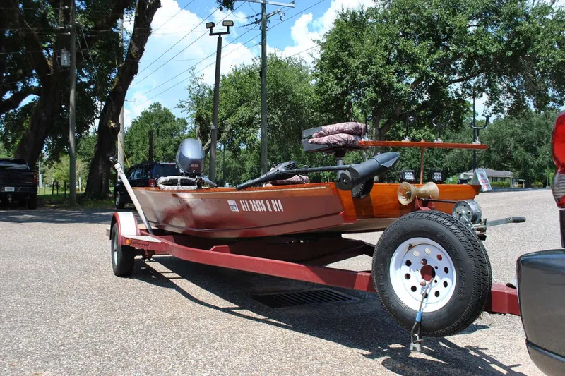 Slide: The Image of Custom 2014 Underwood boat on trailer in parking lot, surrounded by trees and vehicles. - 5