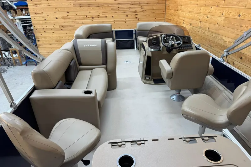 Slide: The Image of 2024 Sylvan Party Fish 820 pontoon boat interior with beige seating and steering console. - 11