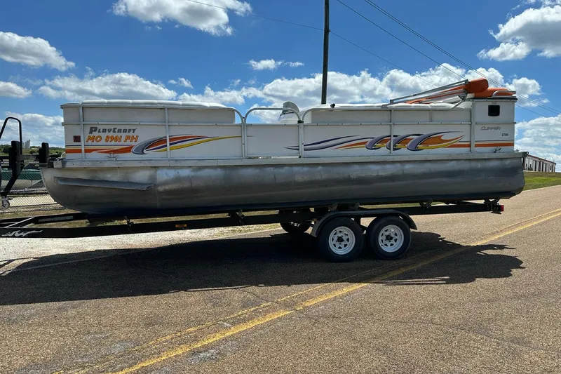 Slide: The Image of 2007 PlayCraft 22 Clipper pontoon boat on trailer under a blue sky. - 0