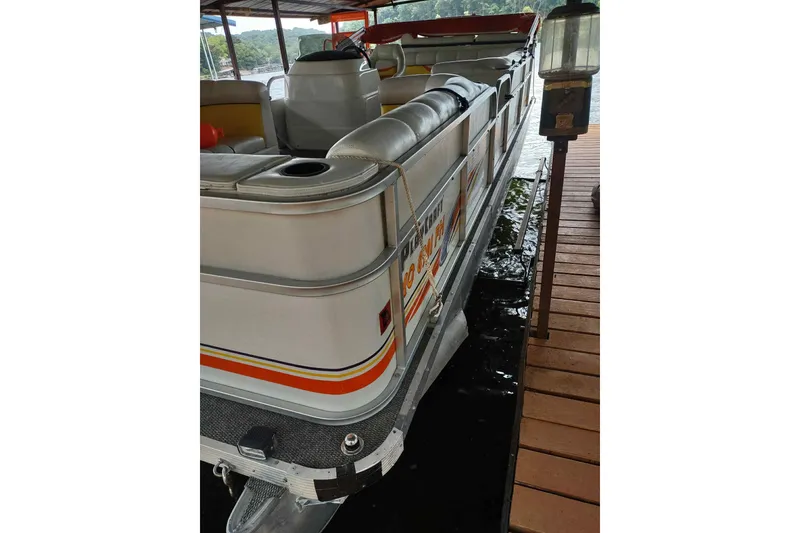 Slide: The Image of 2007 PlayCraft 22 Clipper pontoon boat docked, featuring comfortable seating and vibrant design. - 10