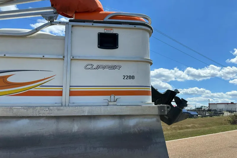 Slide: The Image of 2007 PlayCraft 22 Clipper pontoon boat with vibrant orange and yellow accents under a clear blue sky. - 11
