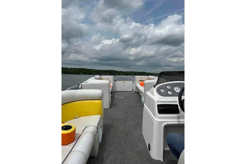 Slide: The Image of 2007 PlayCraft 22 Clipper pontoon boat interior with seating and dashboard on a cloudy day. - 6