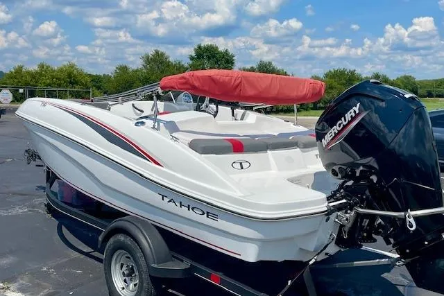 Slide: The Image of 2022 Tahoe T6 boat with Mercury engine on trailer, under a blue sky. - 2