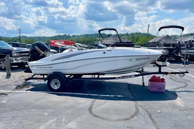 Slide: The Image of 2022 Tahoe T6 boat on trailer in parking lot under cloudy sky. - 4