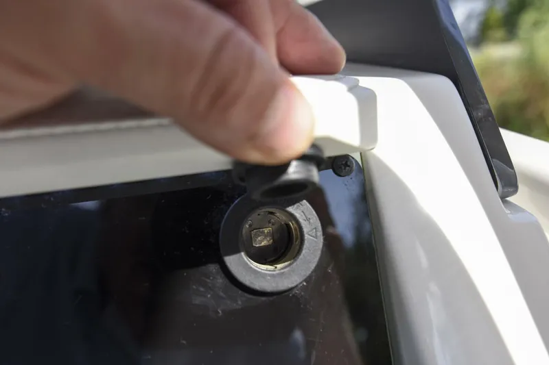 Slide: The Image of Close-up of a hand adjusting a component on a 2022 Ranger 2360 Bay boat. - 34