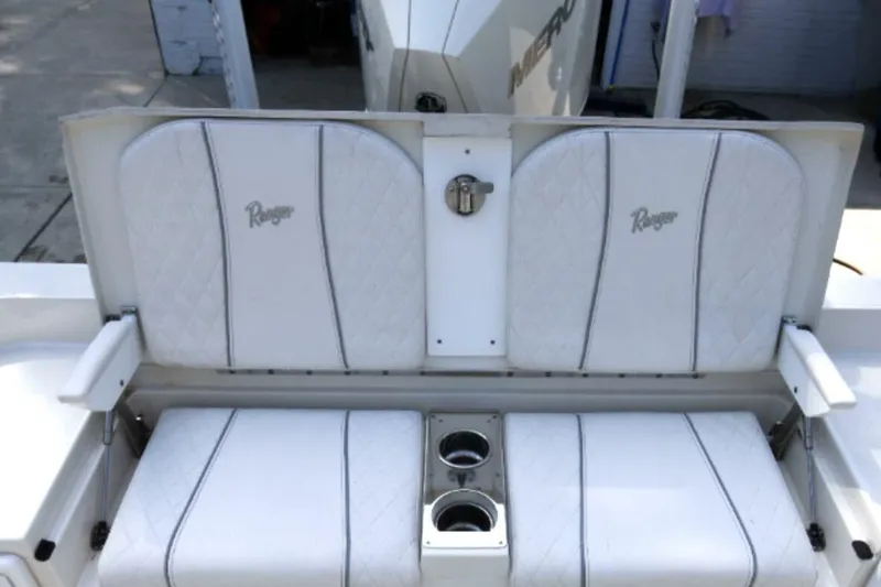 Slide: The Image of 2022 Ranger 2360 Bay boat seating with cup holders, featuring white cushioned seats. - 41