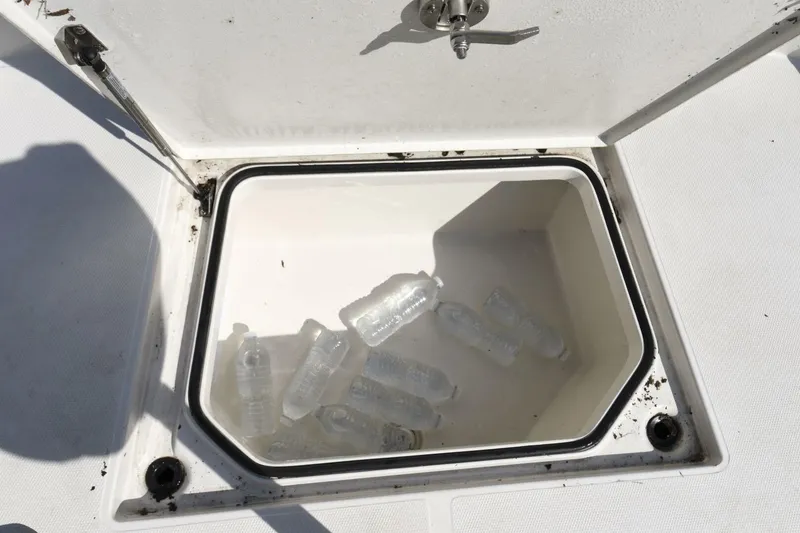 Slide: The Image of Open storage compartment on 2022 Ranger 2360 Bay boat with water bottles inside. - 52