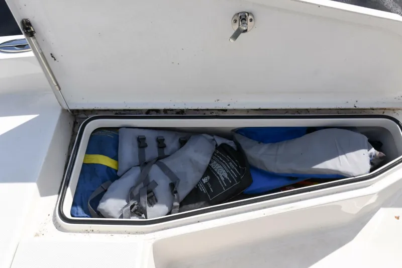 Slide: The Image of Open storage compartment on 2022 Ranger 2360 Bay boat with life jackets inside. - 54