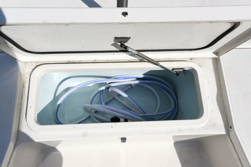 Slide: The Image of Open storage compartment on 2022 Ranger 2360 Bay boat with coiled hose inside. - 57