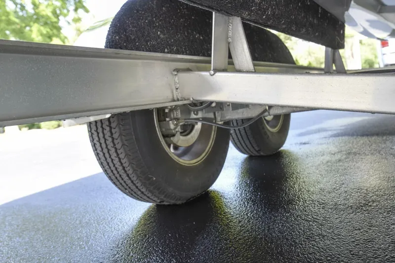 Slide: The Image of Underneath view of 2022 Ranger 2360 Bay trailer wheels on wet pavement. - 87