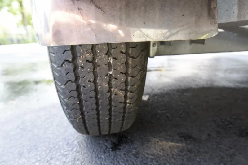 Slide: The Image of Close-up of a 2022 Ranger 2360 Bay trailer tire on asphalt. - 88