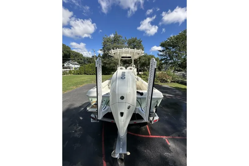 Slide: The Image of 2022 Ranger 2360 Bay boat on trailer, parked outdoors with trees in background. - 9