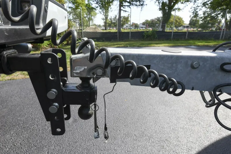 Slide: The Image of Trailer hitch connection on a 2022 Ranger 2360 Bay, featuring coiled safety cables. - 92