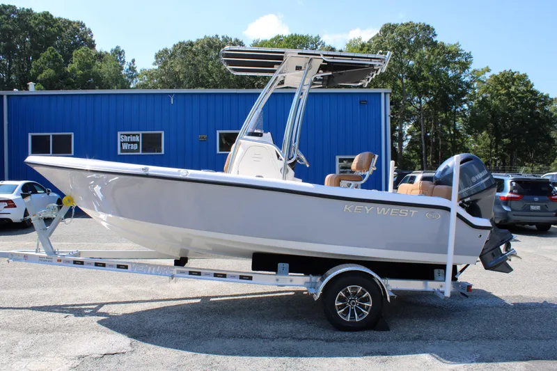 Slide: The Image of 2026 Key West 189 FS boat on trailer, parked outside a blue building. - 11