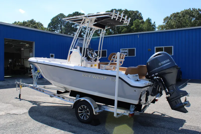 Slide: The Image of 2026 Key West 189 FS boat with Yamaha engine on trailer, parked outside blue building. - 12