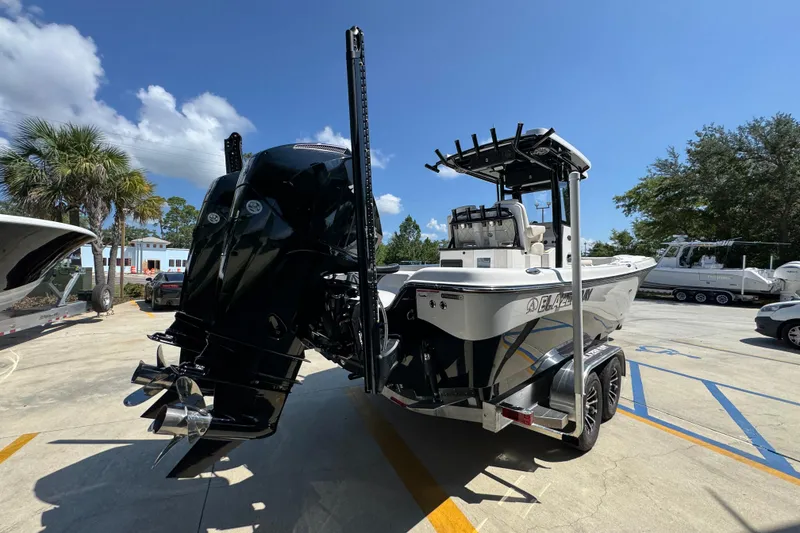 Slide: The Image of 2026 Blazer 2800 Makaira boat on trailer, parked outdoors under blue sky. - 12