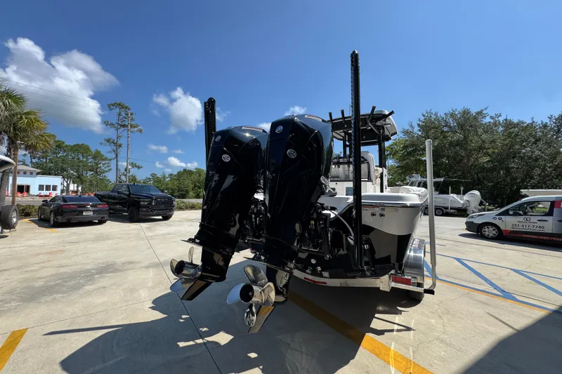 Slide: The Image of 2026 Blazer 2800 Makaira boat with dual outboard motors in a parking lot. - 13
