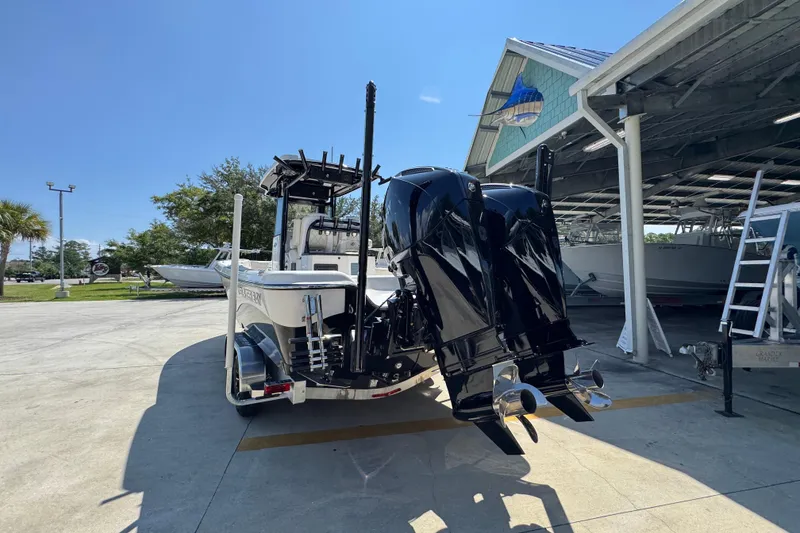 Slide: The Image of 2026 Blazer 2800 Makaira boat with dual engines, parked outdoors under clear blue sky. - 16