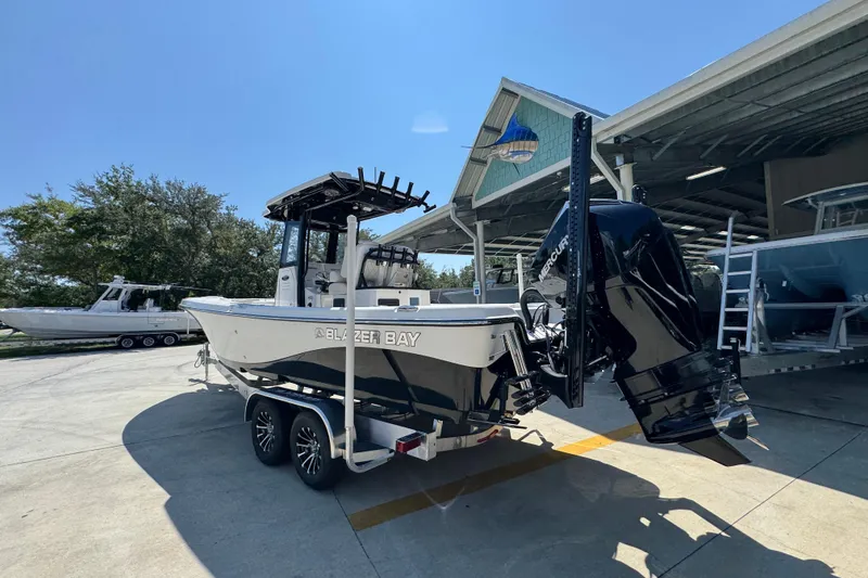 Slide: The Image of 2026 Blazer 2800 Makaira boat on trailer, parked outdoors under clear sky. - 17