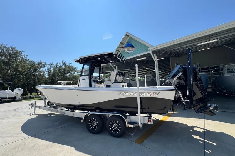 Slide: The Image of 2026 Blazer 2800 Makaira boat on trailer, parked outdoors under clear blue sky. - 18