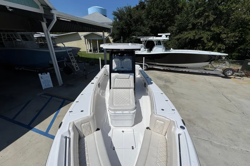 Slide: The Image of 2026 Blazer 2800 Makaira boat with sleek design, parked outdoors in a marina. - 23
