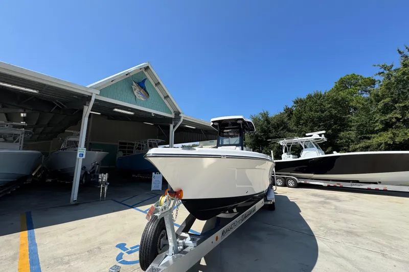 Slide: The Image of 2026 Blazer 2800 Makaira boat on trailer outside a marina under clear blue sky. - 5