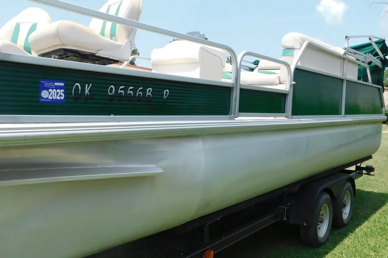 Slide: The Image of 2001 Voyager Pontoons VF20 boat on trailer, green and white design, registration sticker visible. - 3