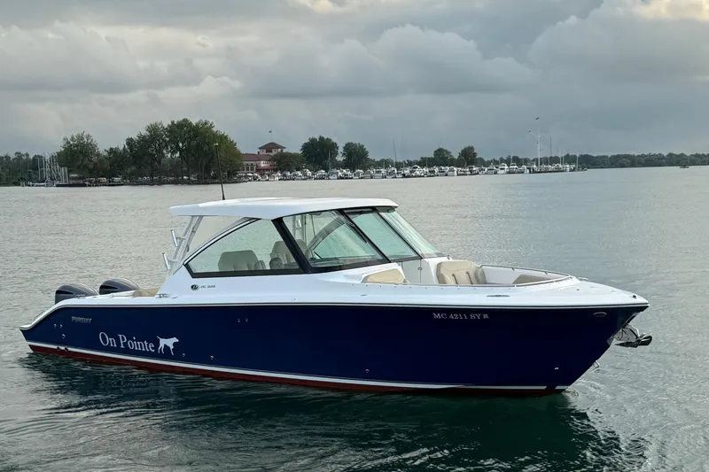 Slide: The Image of 2016 Pursuit DC 325 Dual Console boat on calm water, cloudy sky background. - 12