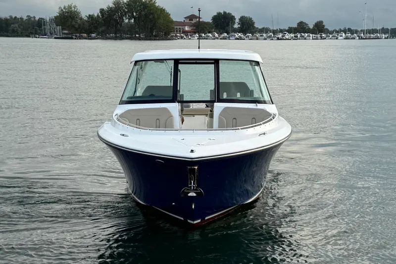 Slide: The Image of 2016 Pursuit DC 325 Dual Console boat on calm water, front view. - 15