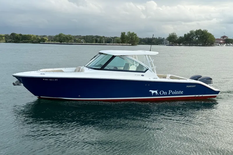 Slide: The Image of 2016 Pursuit DC 325 Dual Console boat named "On Pointe" on calm water. - 17