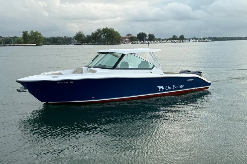 Slide: The Image of 2016 Pursuit DC 325 Dual Console boat on calm water, overcast sky. - 18