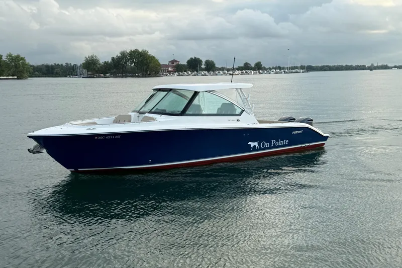Slide: The Image of 2016 Pursuit DC 325 Dual Console boat on calm water, overcast sky. - 20