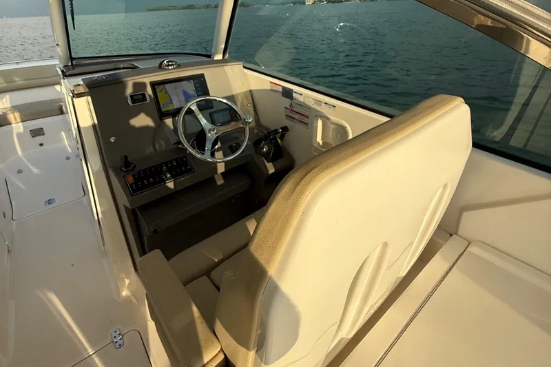 Slide: The Image of 2016 Pursuit DC 325 Dual Console boat interior with steering wheel and navigation display. - 23