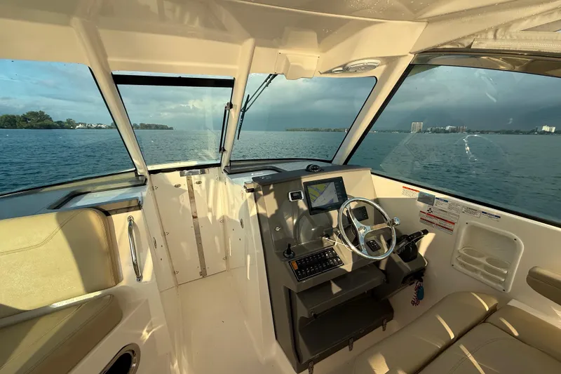 Slide: The Image of 2016 Pursuit DC 325 Dual Console boat interior with steering wheel and navigation system. - 24