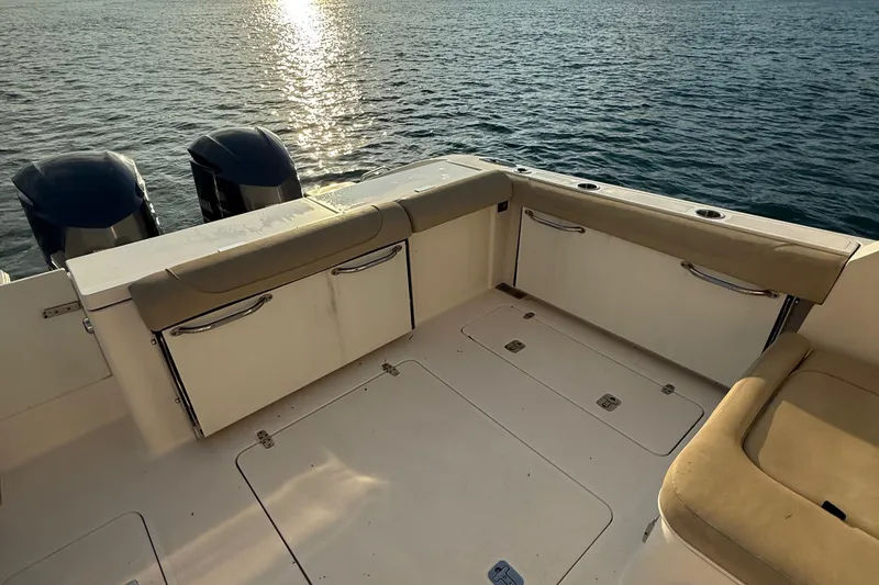 Slide: The Image of 2016 Pursuit DC 325 Dual Console boat interior with twin engines on calm water. - 28