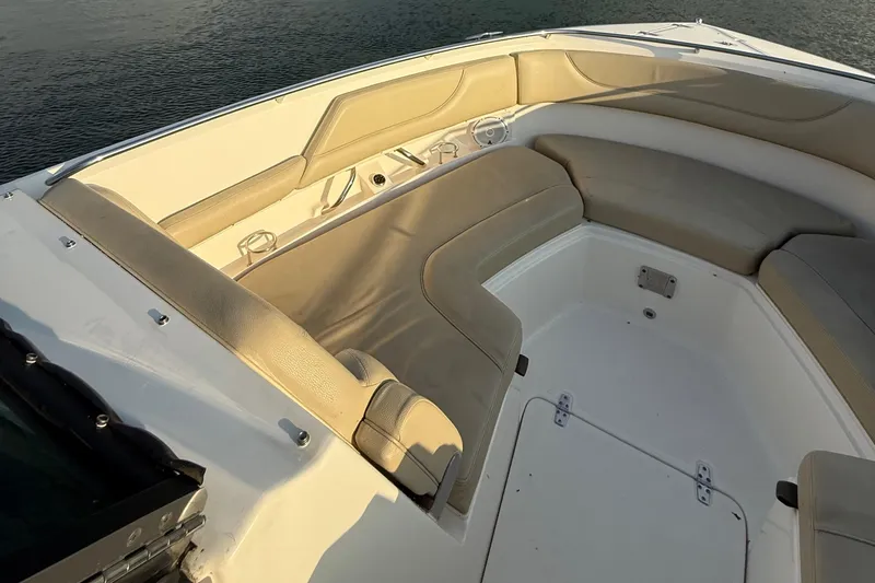 Slide: The Image of 2016 Pursuit DC 325 Dual Console boat interior with beige seating, on calm water. - 29