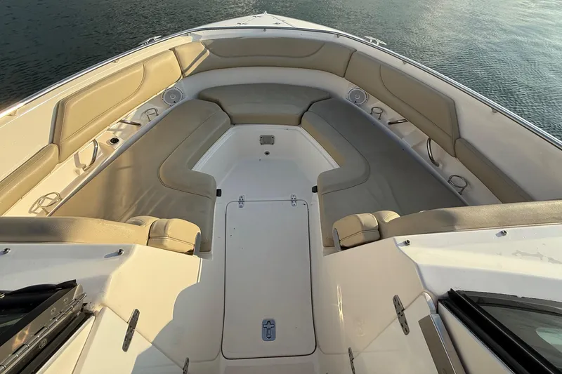 Slide: The Image of 2016 Pursuit DC 325 Dual Console boat interior with beige seating and storage compartments. - 30