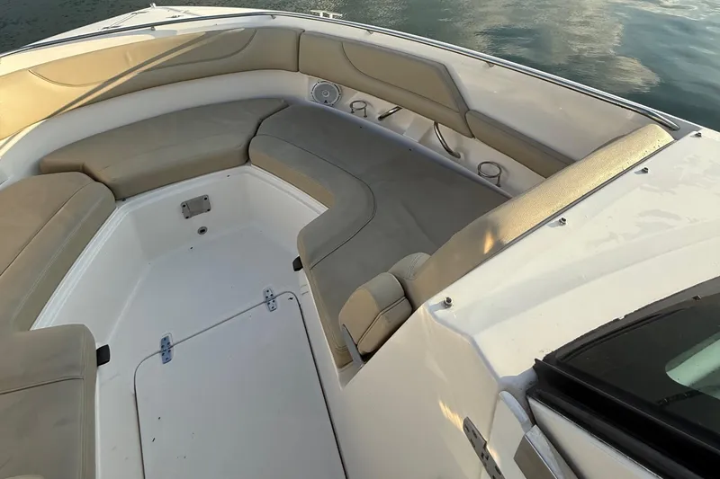 Slide: The Image of 2016 Pursuit DC 325 Dual Console boat interior with beige seating and storage compartments. - 31