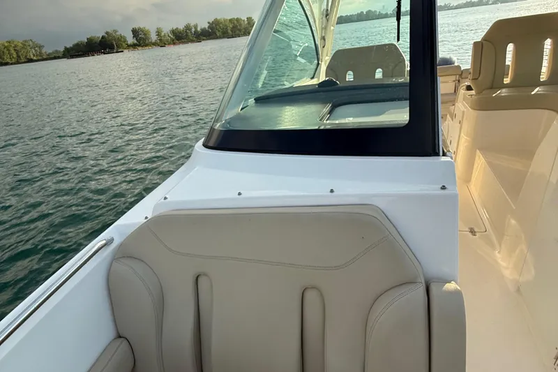 Slide: The Image of 2016 Pursuit DC 325 Dual Console boat interior with seating, on calm water. - 32