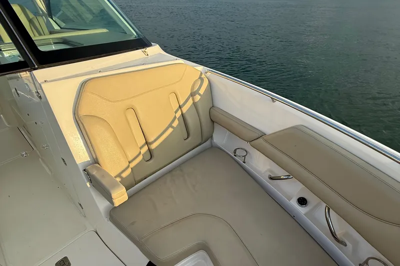 Slide: The Image of 2016 Pursuit DC 325 Dual Console boat interior with beige seating, overlooking water. - 36
