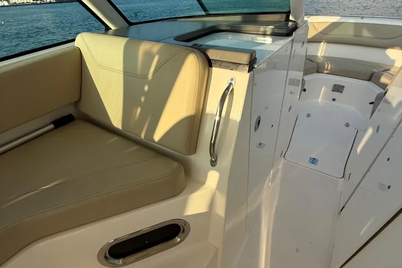 Slide: The Image of 2016 Pursuit DC 325 Dual Console interior with beige seating and sleek design. - 37