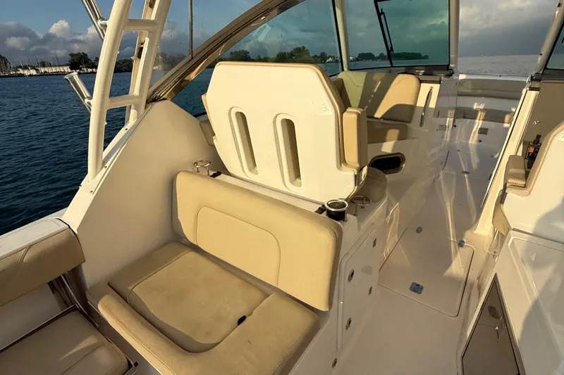 Slide: The Image of 2016 Pursuit DC 325 Dual Console boat interior with beige seating and ocean view. - 38