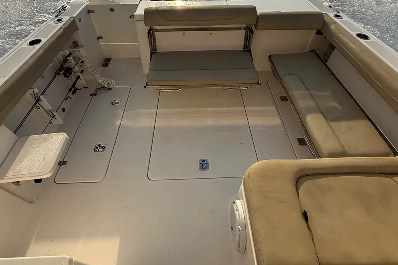 Slide: The Image of 2016 Pursuit DC 325 Dual Console boat interior with cushioned seating and storage compartments. - 39
