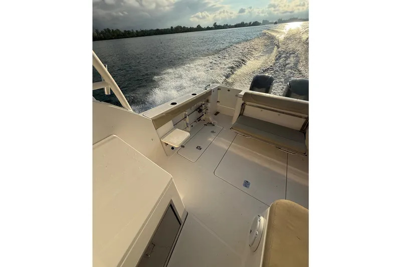 Slide: The Image of 2016 Pursuit DC 325 Dual Console boat cruising on open water at sunset. - 41