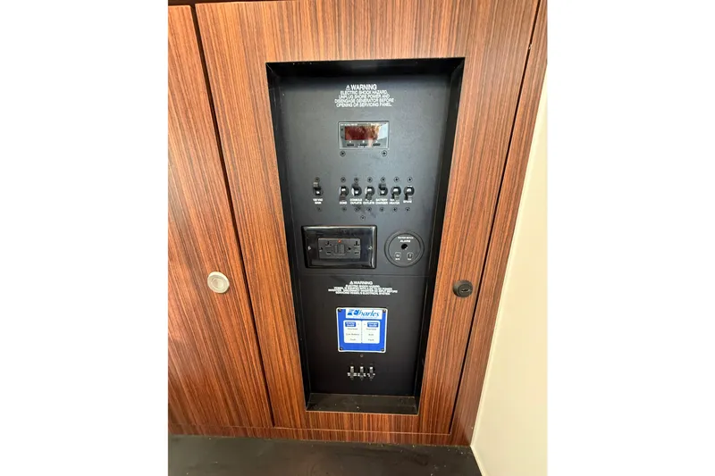 Slide: The Image of Electrical panel on 2016 Pursuit DC 325 Dual Console boat, featuring switches and outlets. - 46